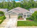 Aerial view of a well-maintained single-story home with a two-car garage and landscaped yard at 409 Nowell Loop, Deland, FL 32724