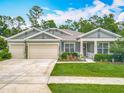 Beautiful single-story home with manicured lawn, complemented by a two-car garage and inviting front porch at 409 Nowell Loop, Deland, FL 32724