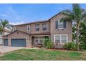 Charming two-story home with well-manicured lawn, mature palms, and a welcoming front porch at 4604 Barbados Loop, Clermont, FL 34711