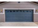 A blue two car garage door with decorative windows and carriage house style lighting at 4604 Barbados Loop, Clermont, FL 34711