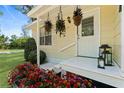Inviting front porch with decorative hanging plants and colorful flower bed at 51 Silk Moss Ct, South Daytona, FL 32119