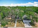 Overhead view of a single-story home featuring a front-facing garage and gravel walkway, surrounded by lush trees at 511 Doctors Dr, Oviedo, FL 32765