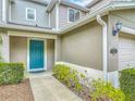 Townhome exterior featuring a teal front door and well maintained landscaping at 564 Mount Olympus Blvd, New Smyrna Beach, FL 32168