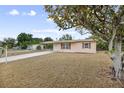 Inviting single-story home featuring a well-maintained lawn and mature tree at 566 S Floyd Cir, Deltona, FL 32725