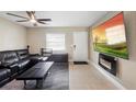 Inviting living room with tile floors, mounted fireplace, and a comfortable leather sofa set at 6509 Lake Lerla Dr, Apopka, FL 32712