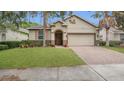 Charming single Gathering house featuring tan siding, arched doorway, and manicured lawn at 680 Preakness Cir, Deland, FL 32724