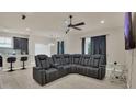 Comfortable living room featuring large sectional sofa, ceiling fan, and neutral color palette at 680 Preakness Cir, Deland, FL 32724