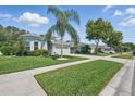 Well-kept home with a lush lawn, palm tree, and a two-car garage at 6820 Vintage Ln, Port Orange, FL 32128