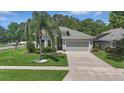 Charming home with lush green lawn and a palm tree accenting the driveway at 6820 Vintage Ln, Port Orange, FL 32128