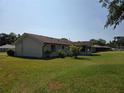 Expansive backyard showcasing the home's rear exterior with a neutral siding and well-maintained lawn under a blue sky at 808 Scrub Oak St, South Daytona, FL 32119