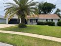 Lovely home with a manicured lawn, complemented by a brick exterior and accented by a mature shade providing palm tree at 808 Scrub Oak St, South Daytona, FL 32119