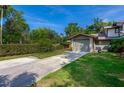 A well-manicured front yard features lush green grass, healthy hedges, and a paved driveway at 834 Sugar House Dr, Port Orange, FL 32129