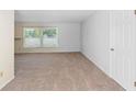 Bright bedroom with neutral carpeting, a window for natural light, and a white door, ready for personalization at 990 W French Ave, Orange City, FL 32763