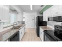 Bright kitchen with white cabinets, granite countertops, stainless steel appliances, and ample counter space at 990 W French Ave, Orange City, FL 32763