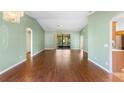 Bright living room with high ceilings, hardwood floors, and a sliding glass door to the lanai at 1120 W Glen Falls Rd, Deland, FL 32720