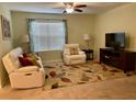 Cozy living room featuring a comfortable recliner, sofa, accent lamps, and an area rug over carpet at 119 Fishermans Cove Dr, Edgewater, FL 32141