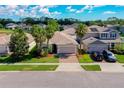 Suburban home with a two-car garage, brick driveway, mature palm trees, and well-maintained lawn and landscaping at 1233 Girog Ave, Port Orange, FL 32129