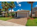 Charming single-story house with a two-car garage, brick driveway, and beautifully landscaped front yard with palm trees at 1233 Girog Ave, Port Orange, FL 32129