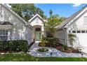 Inviting home entrance with a tiled walkway, a light green door, and lush landscaping at 1412 Bent Oaks Blvd, Deland, FL 32724