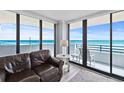 Living room with ocean views, sliding glass doors to a balcony and comfortable seating at 1420 N Atlantic Ave # 202, Daytona Beach, FL 32118