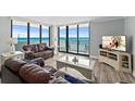 Bright living room featuring cozy seating, sliding glass doors, and stunning ocean views at 1420 N Atlantic Ave # 202, Daytona Beach, FL 32118