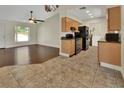 Well-equipped kitchen with black appliances, tile flooring, wooden cabinetry, and adjacent laundry area at 1562 Monroe St, Deland, FL 32720