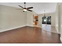 Open-concept living space with wood flooring, ceiling fan, and sliding glass doors leading to the outdoors at 1562 Monroe St, Deland, FL 32720