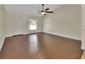 Bright, spacious living room featuring wood floors, a ceiling fan, and ample natural light from a large window at 1562 Monroe St, Deland, FL 32720