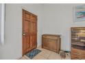 Welcoming entryway with a wood door, beige tile floor, and a decorative cabinet at 1608 Raleigh Ave, Daytona Beach, FL 32117