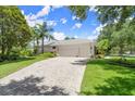 Long, spacious driveway with a three car garage and manicured lawn at 1653 Promenade Cir, Port Orange, FL 32129
