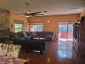 Spacious living room featuring a stone fireplace, dark wood floors, and access to a covered porch at 1725 Turtle Hill Rd, Enterprise, FL 32725