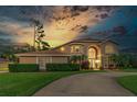 Beautiful two-story home with a well-manicured lawn, mature trees, and a circular driveway providing a welcoming curb appeal at 18 Foxfords, Ormond Beach, FL 32174