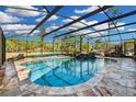 Screened pool with stone decking and a rock waterfall feature at 19343 Moorgate St, Orlando, FL 32833