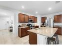 Bright kitchen with granite countertops, a center island with barstool seating, and stainless steel appliances at 211 Duke Dr, Deland, FL 32724
