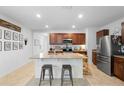 Open concept kitchen features a center island with barstool seating, granite countertops, and stainless appliances at 211 Duke Dr, Deland, FL 32724