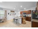 Open concept kitchen features a center island with barstool seating, granite countertops, and stainless appliances at 211 Duke Dr, Deland, FL 32724