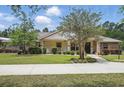 Attractive single-story home with inviting porch, well-kept lawn, and established trees at 226 Treeline Ln, Ormond Beach, FL 32174