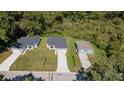 An aerial view showcases three houses, each with driveways, in a lush green environment at 248 S Virginia Ave, Deland, FL 32724