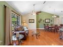 Cozy living room with hardwood floors, a ceiling fan, and a dining area bathed in natural light at 25 Pine Glen Dr, Debary, FL 32713