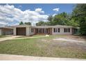 Charming single-story home with a brick and white exterior, a well-manicured lawn, and a driveway leading to an attached garage at 2842 English Dr, Deltona, FL 32738