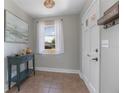 Inviting foyer with neutral walls, a console table, tile flooring, and a view of the front door and window at 2842 English Dr, Deltona, FL 32738