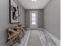 Inviting foyer with neutral walls, stylish wood-look flooring, a decorative table, and an art piece at 3026 Adrian Dr, Ormond Beach, FL 32174