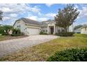 Charming home with a winding brick driveway, mature landscaping, and attached garage at 319 Bellingrath Ter, Deland, FL 32724