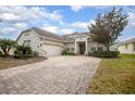 Charming home with a winding brick driveway, mature landscaping, and attached garage at 319 Bellingrath Ter, Deland, FL 32724