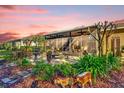 View of the screened lanai with outdoor furniture, lush landscaping, and garden decor at 320 W Victoria Trails Blvd, Deland, FL 32724