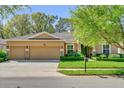Charming home featuring a three-car garage, manicured lawn, and decorative stone accents at 320 W Victoria Trails Blvd, Deland, FL 32724