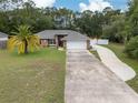 Charming single-story home boasts a well-maintained lawn, long driveway, and attached two-car garage at 3210 Whitehorse Ct, Deltona, FL 32738