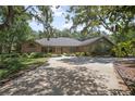 Spacious brick home featuring a circular driveway and lush, mature trees at 3357 Black Willow Trl, Deland, FL 32724