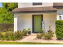 Charming home entrance with a green door, welcome sign, and beautifully landscaped walkway at 348 Southern Winds Blvd, Deland, FL 32720