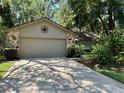 Charming home features a stone facade and well-manicured landscaping around a two car garage at 37 Meadowwood Trl, Deland, FL 32724